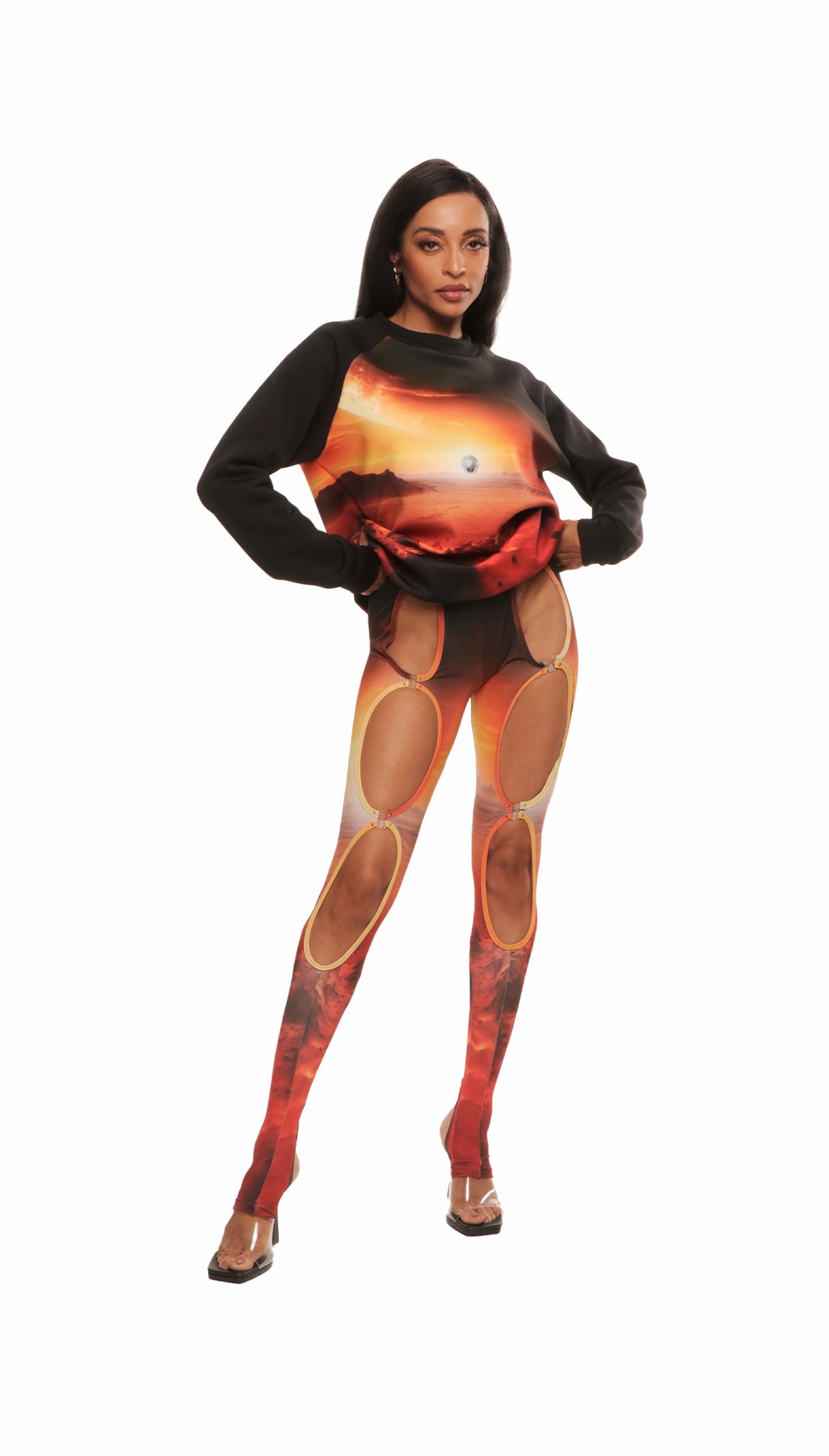 Woman who looks like Beyoncé or Aaliyah wears a cosmic mars sunset printed Italian fleece sweater with matching leggings, front view