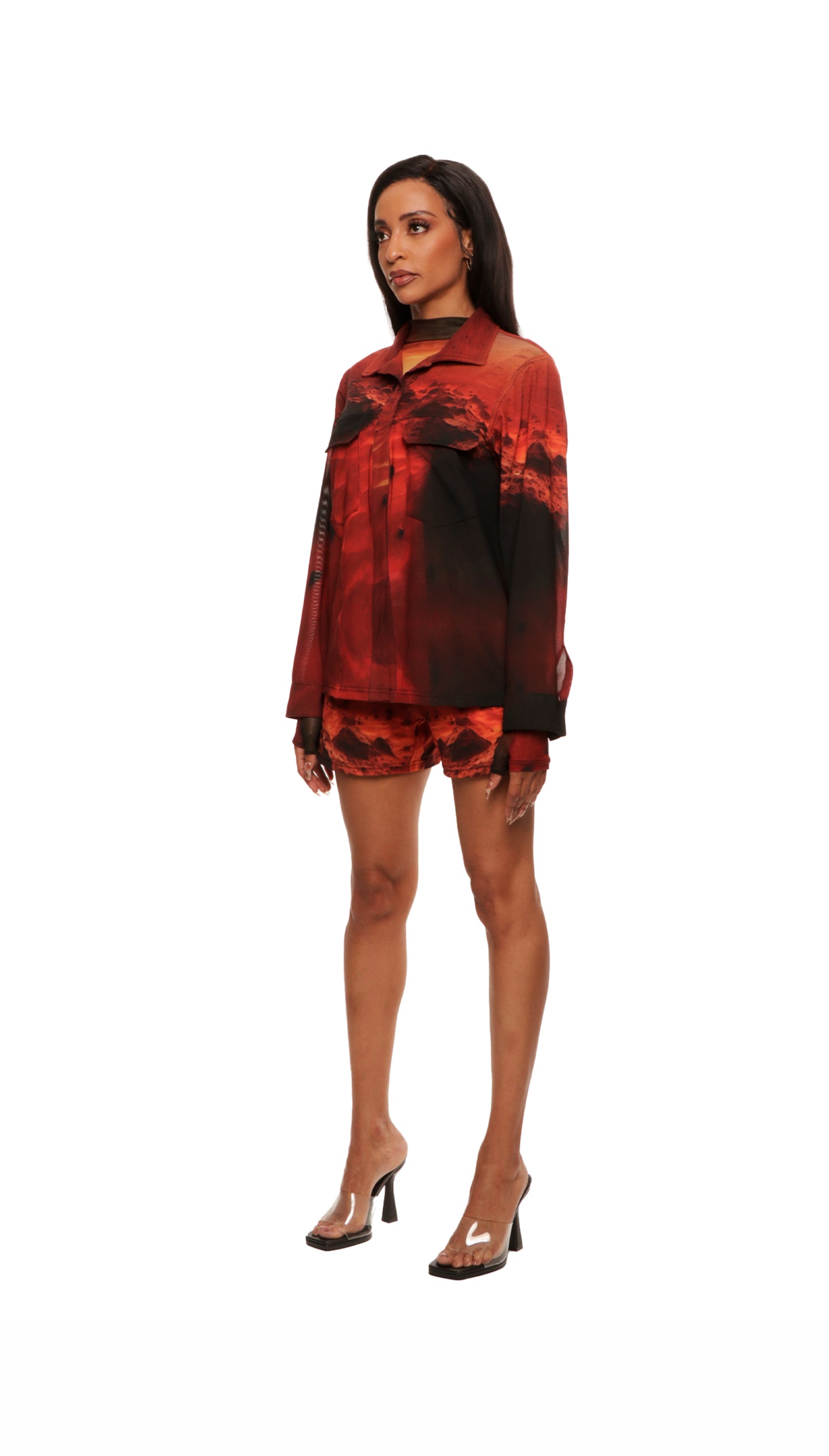 Woman who looks like Beyoncé or Aaliyah wears a cosmic sunset printed long sleeve button up shirt with snaps, side view