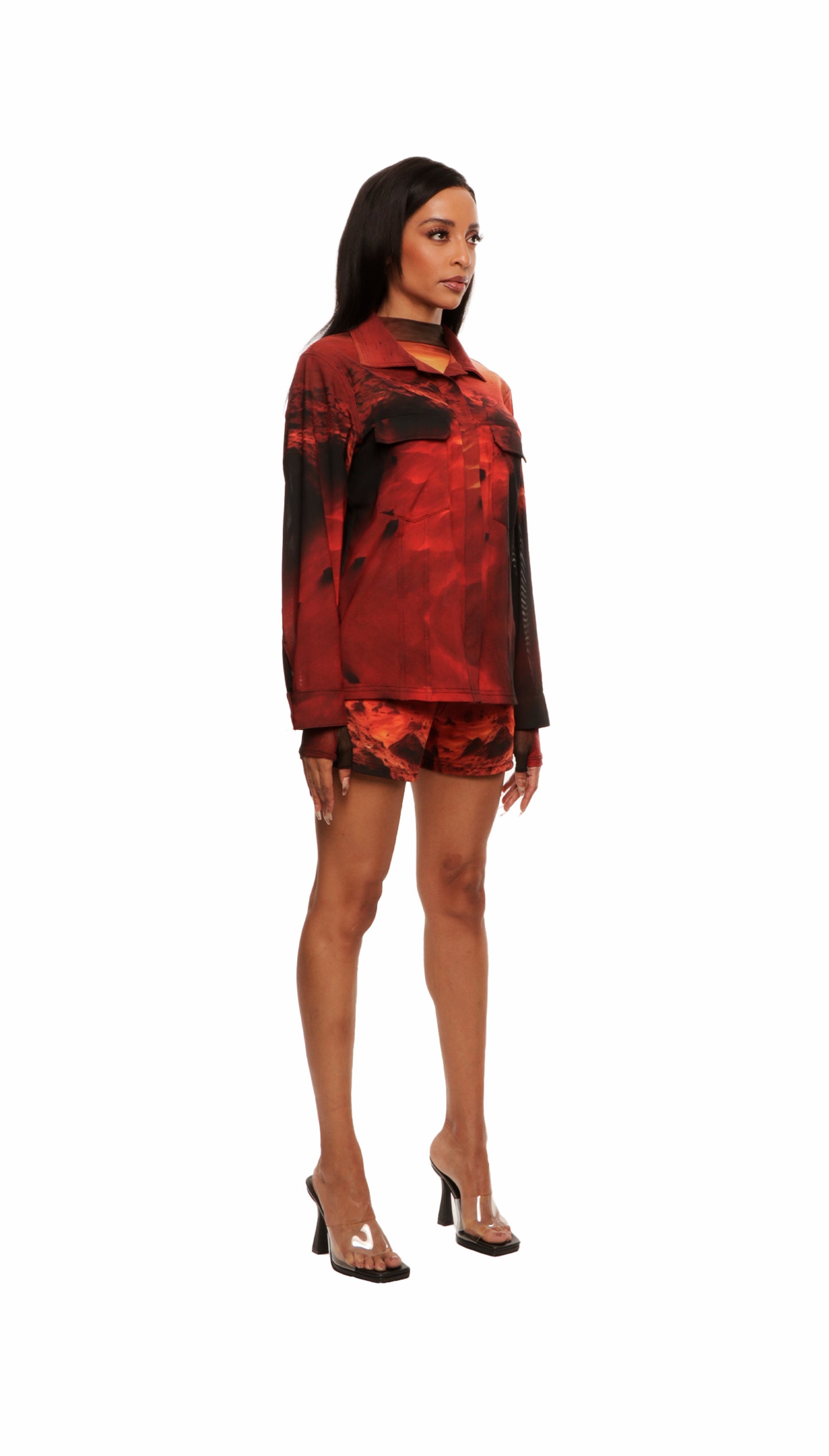 Woman who looks like Beyoncé or Aaliyah wears a cosmic sunset printed long sleeve button up shirt with snaps, side view
