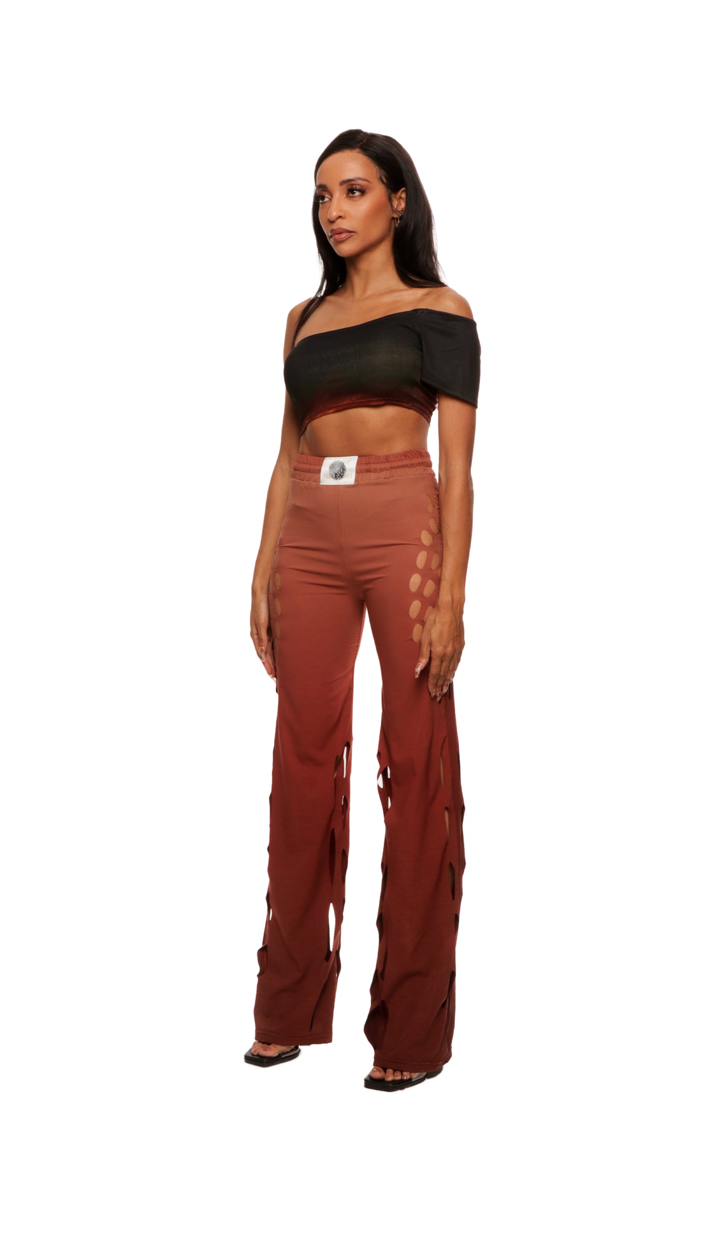 Woman who looks like Beyoncé or Aaliyah wears gradient brown toned bottoms or pants with cutout details on the sides, side view