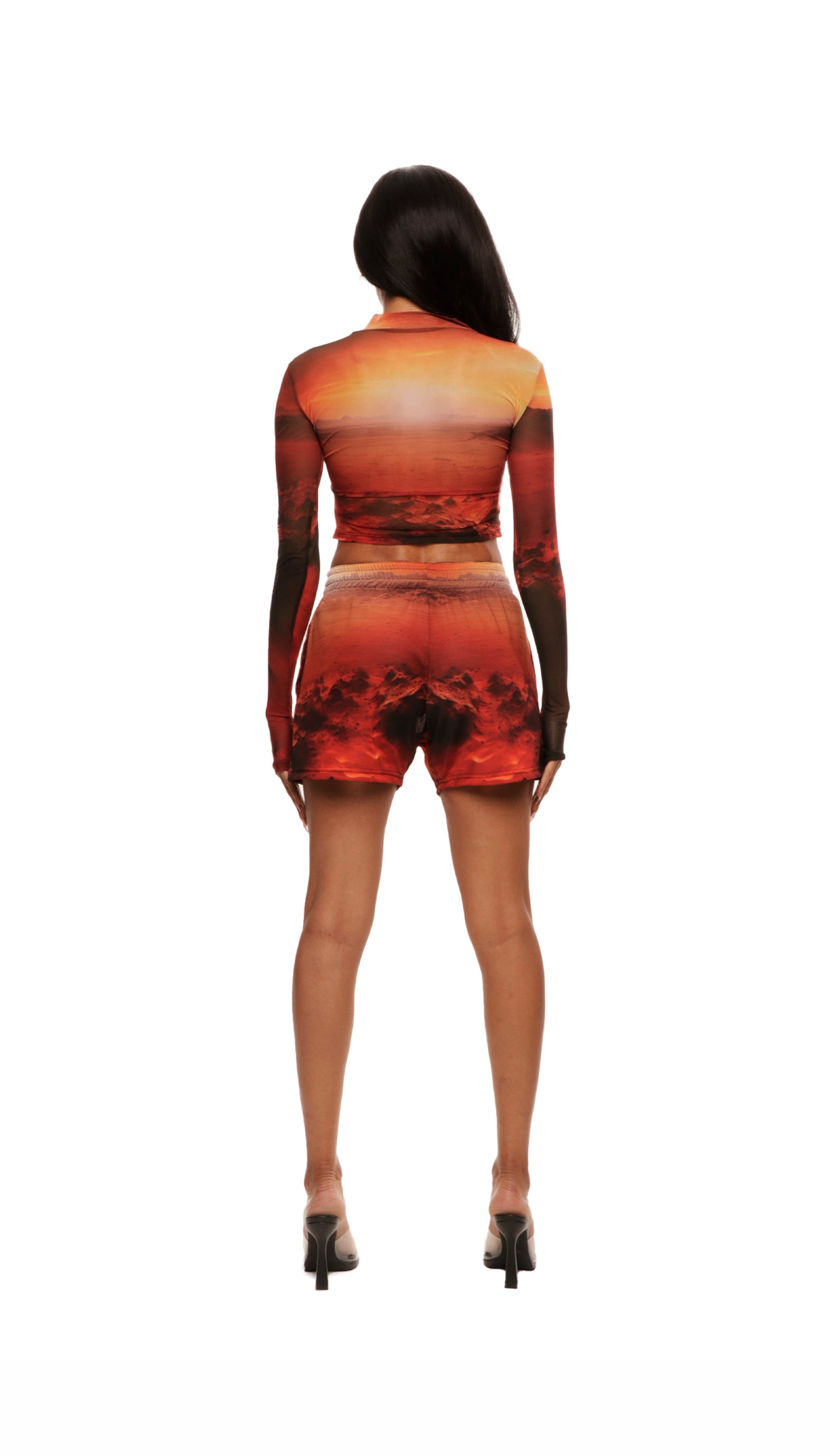 Woman who looks like Beyoncé or Aaliyah wears a cosmic sunset on mars printed long sleeve mesh top with gauntlet sleeve, back view