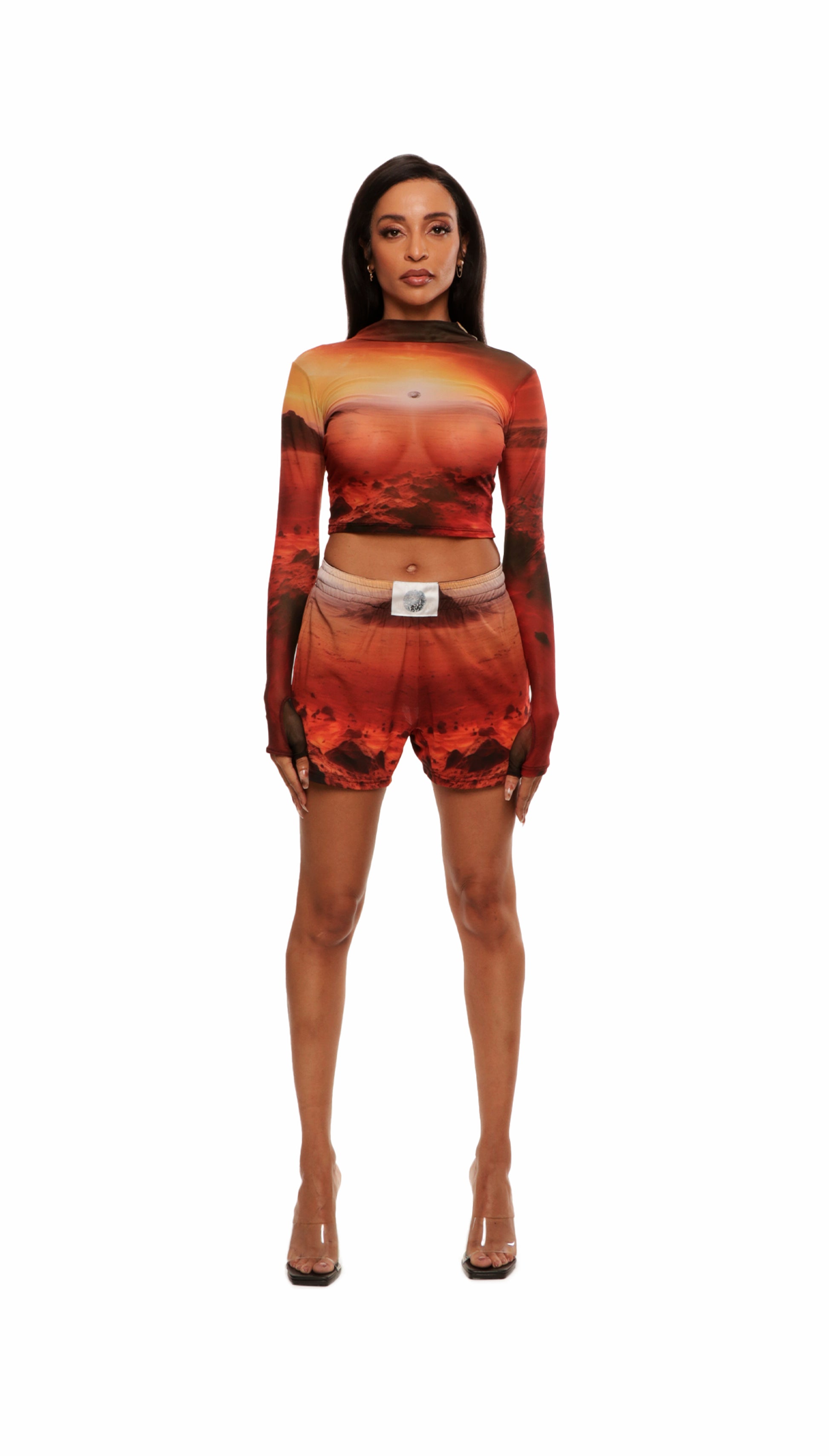 Front view of woman who looks like Beyoncé or Aaliyah wears cosmic Mars sunset printed mesh short basketball shorts QR logo detail