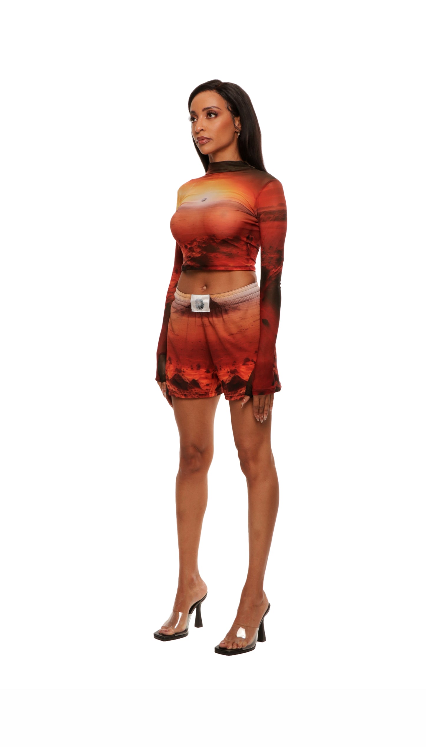 Side view of woman who looks like Beyoncé or Aaliyah wears cosmic Mars sunset printed mesh short basketball shorts with QR logo detail