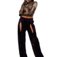 Woman who looks like Beyoncé or Aaliyah wears berry colored stretch smooth nylon pants with open detail front, paired with a grey stretch mesh long sleeve shirt top. Front view.