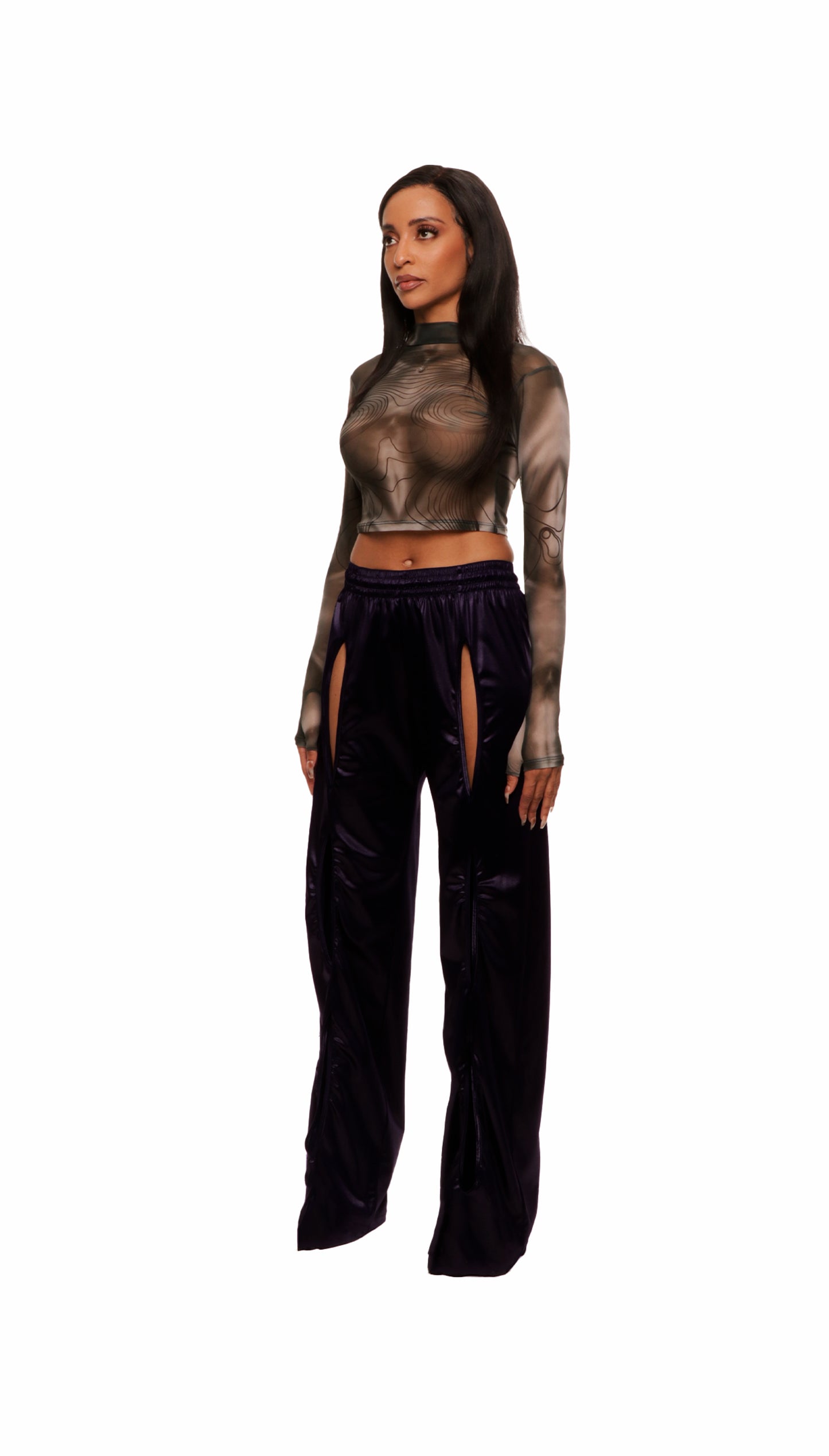 Woman who looks like Beyoncé or Aaliyah wears a grey stretch mesh long sleeve top custom printed to contour the body and resemble an oil spill. Side view paired with shiny purple pants.