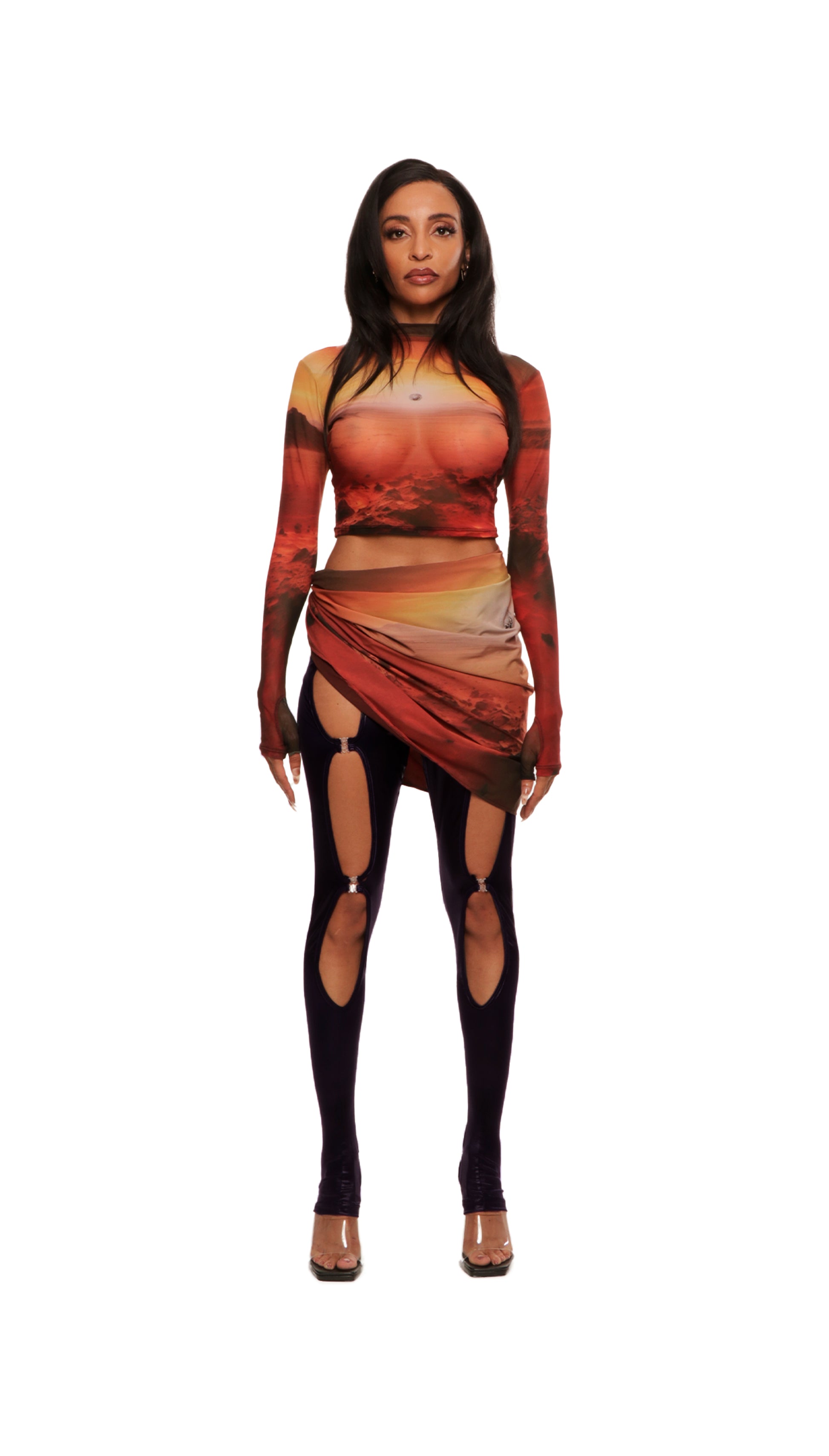 Woman who looks like Beyoncé or Aaliyah wears berry colored stretch cooling smooth nylon leggings with open detail clasp front and stirrup style opening, front view. Paired with sunset on Mars printed long sleeve top.