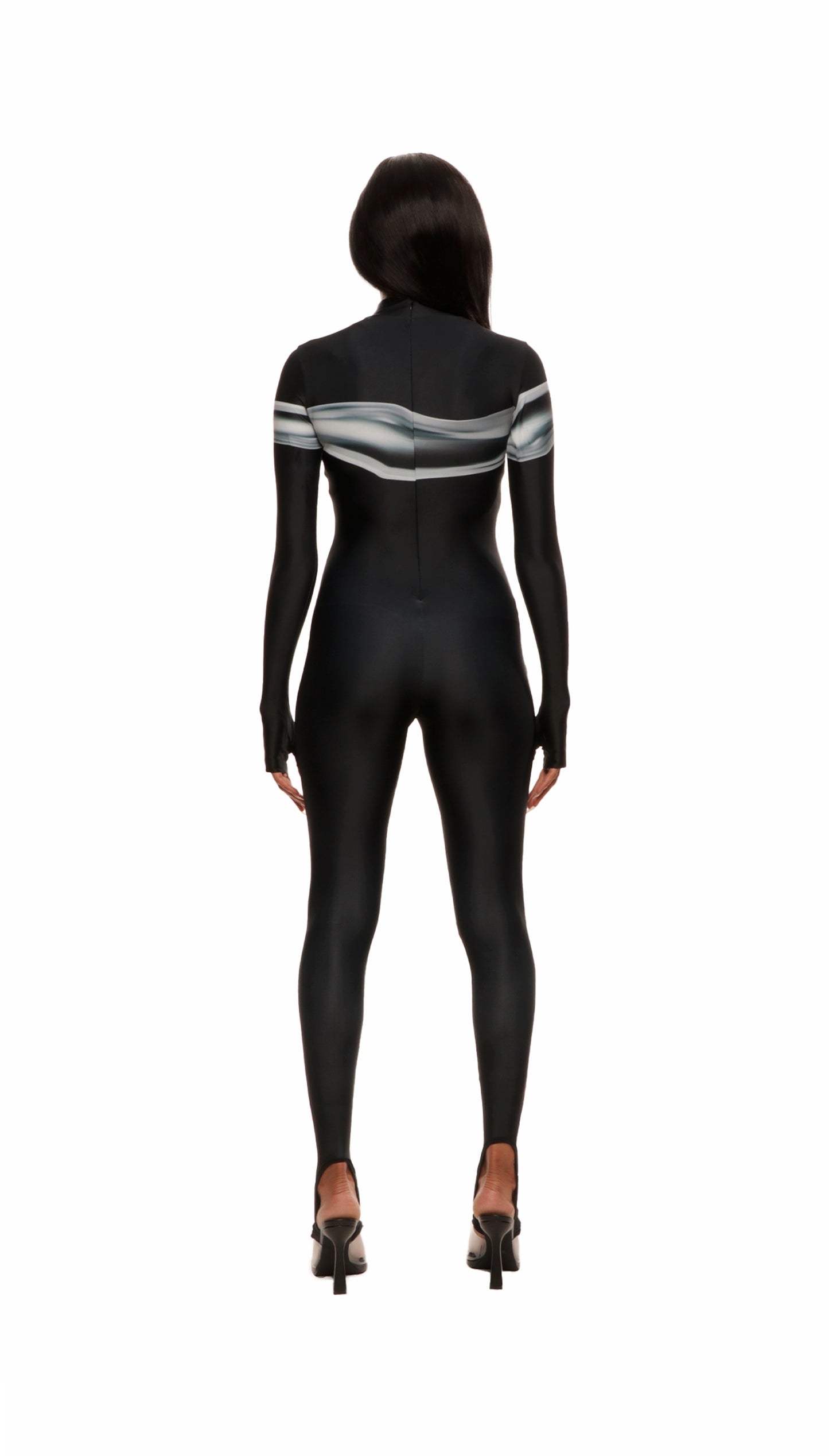 Woman wears black printed wetsuit or catsuit with chrome detail across chest and QR logo with heel cutout and back zipper