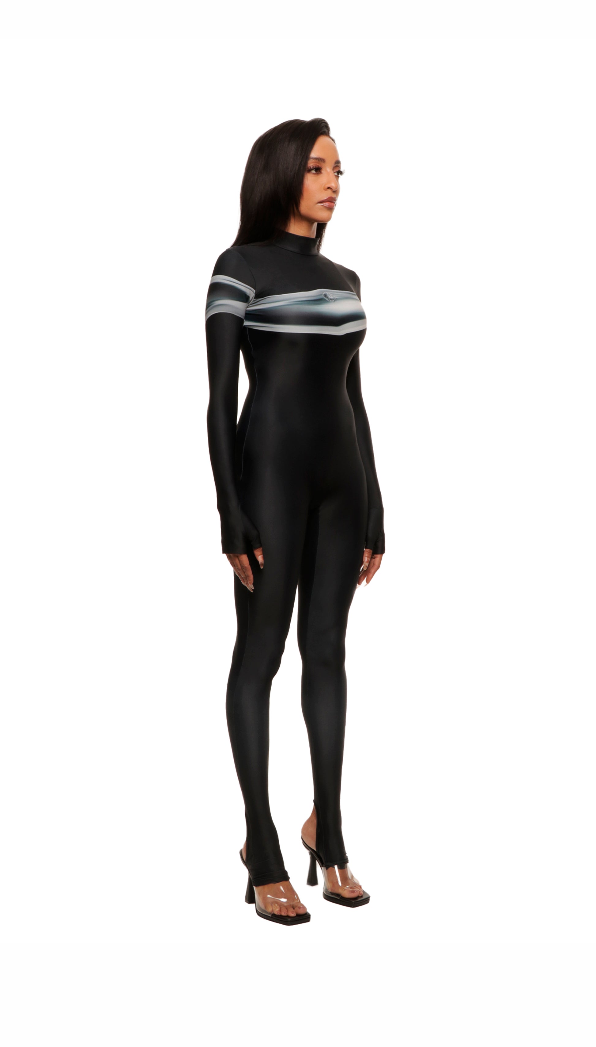 Woman wears black printed wetsuit or catsuit with chrome detail across chest and QR logo with heel cutout